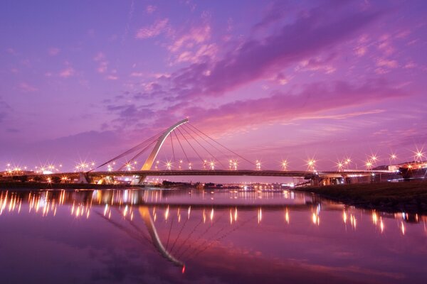 Reflexão da ponte na água ao pôr do sol