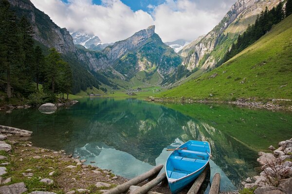 Blaues Boot auf dem Hintergrund der schönen Berge