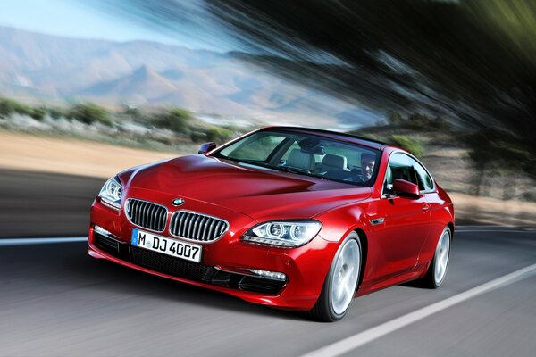 L homme conduit une voiture de couleur rouge