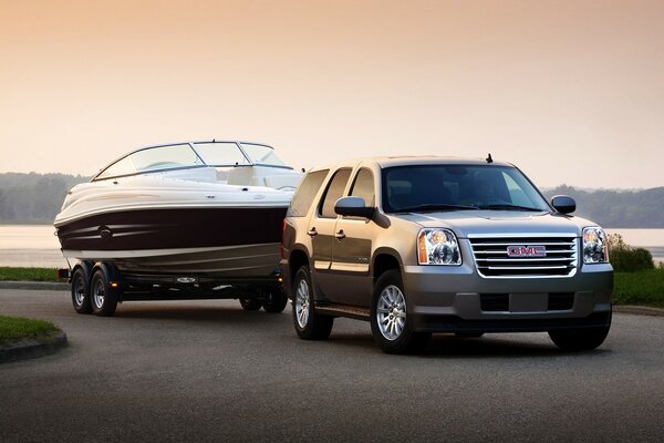 An SUV transports a boat on an asphalt road