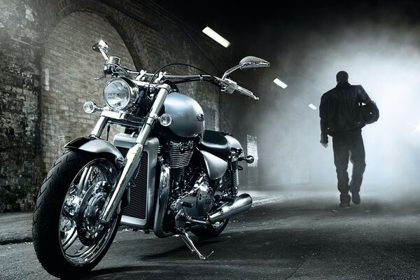 Motorcyclist with a motorcycle in a tunnel with foggy