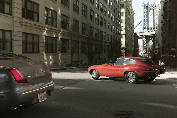 Coche viejo rojo en la ciudad en una intersección