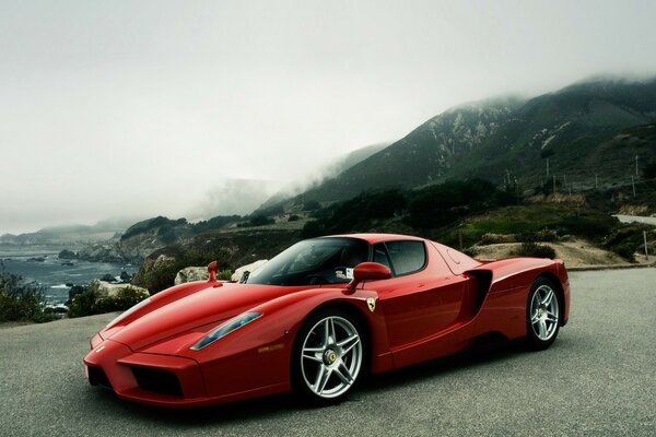 Roter Ferrari auf dem Hintergrund der Berge