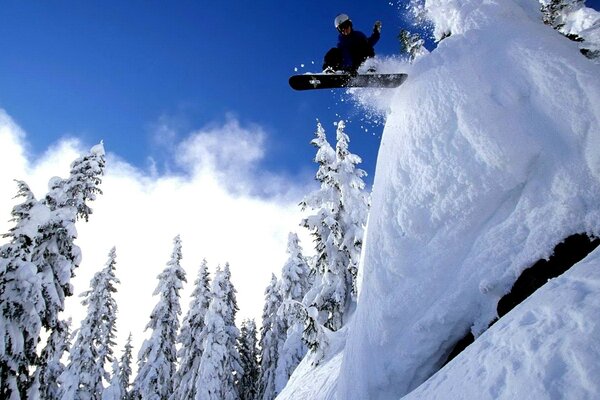 Salto dello snowboarder su un trampolino di neve