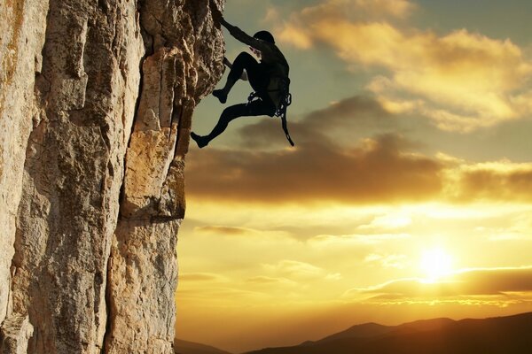 Scalatore che si arrampica sul tramonto