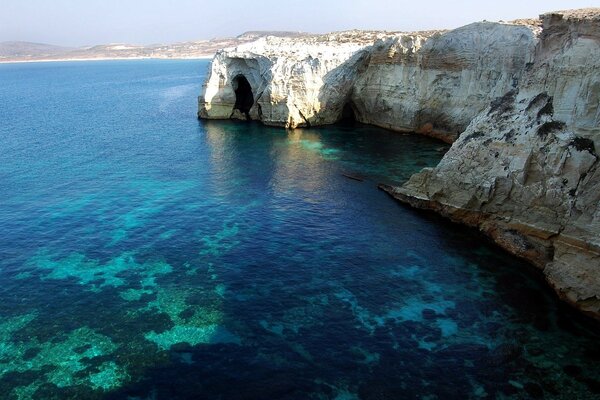 Les eaux bleues grecques lavent les rochers