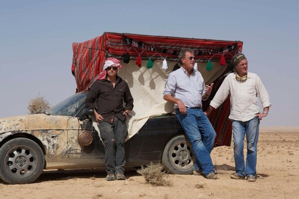 Trois hommes adultes près de la voiture