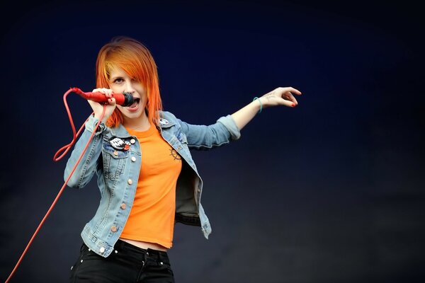 Cantora com cabelo vermelho em fundo preto