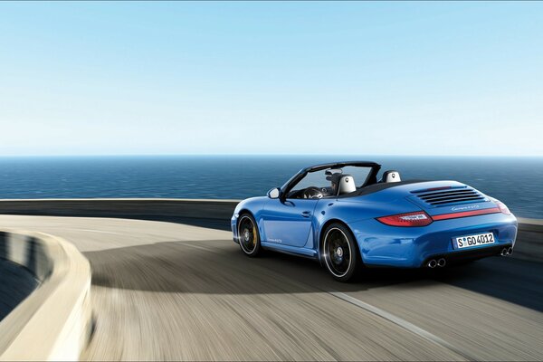 A blue Porsche is moving across the bridge