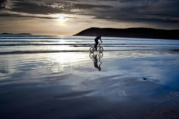 Ciclista recorriendo la costa al atardecer