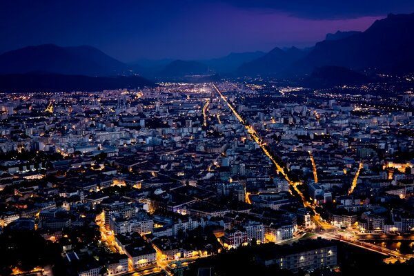 Città notturna sullo sfondo delle montagne