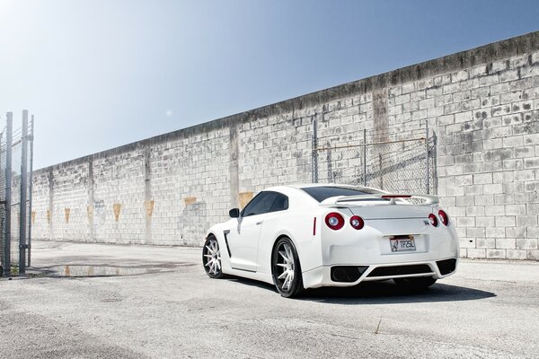 White Nissan on a brick wall background