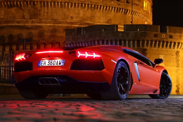 Lamborghini rouge dans la rue pendant la nuit