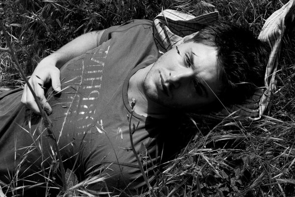 Dean lying in the grass view the play of light TV series supernatural