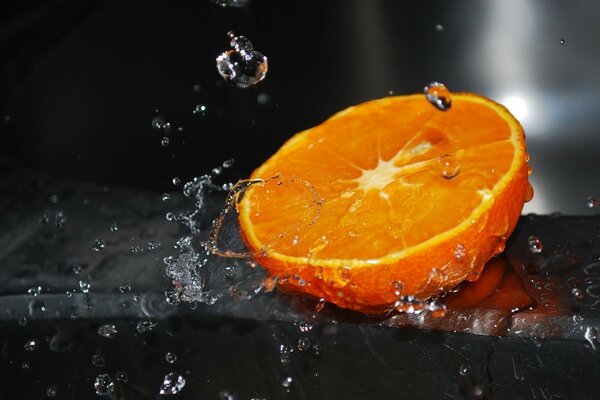 Media naranja bajo las gotas de lluvia