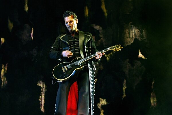 A musician on stage with a guitar in his hands