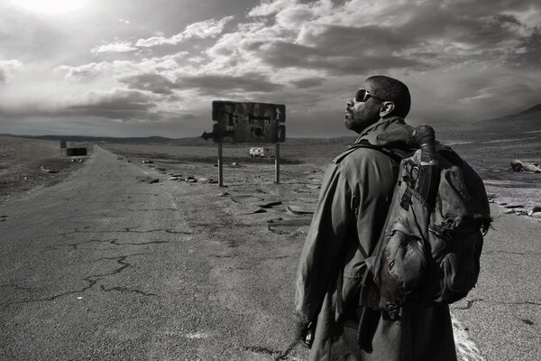 Legend. A black man with a backpack in the desert