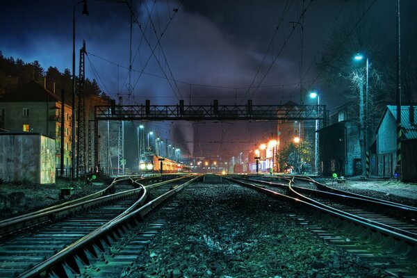 Vías de tren nocturnas a la luz de las luces