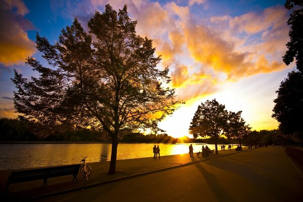 People walking on the embankment at sunset