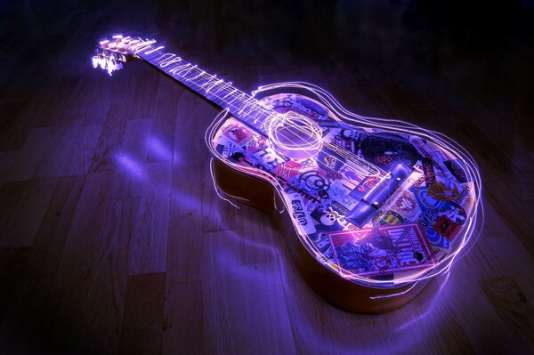 The illuminated guitar is lying on the floor