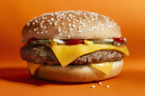 Juicy cheeseburger on an orange background