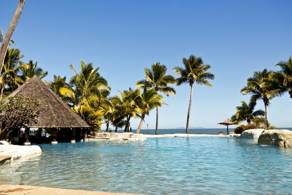 Viajes tropicales. Cabaña y playa en la costa azul