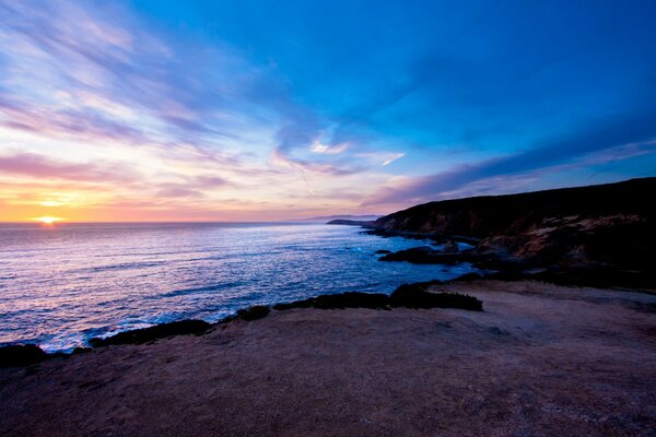 El cielo azul de la tarde y el sol se ponen en las profundidades del océano