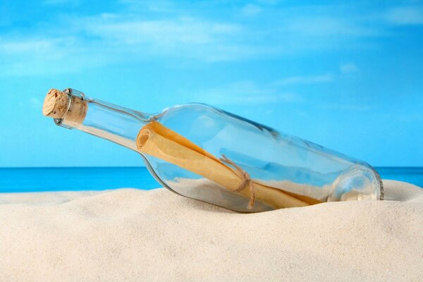 A bottle with a letter in the sand on the background of the sea