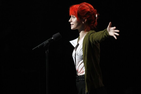 Ragazza che canta con il microfono sul palco