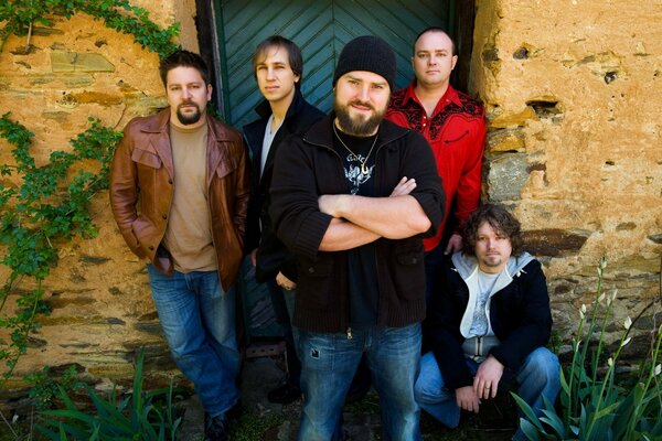 Five men pose at the door of the house