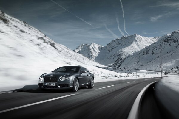 Bentley fährt auf der Straße. In den schneebedeckten Bergen