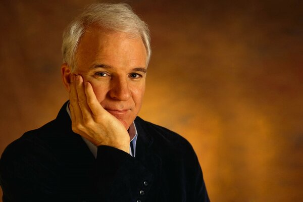 A gray-haired man in a blue jacket