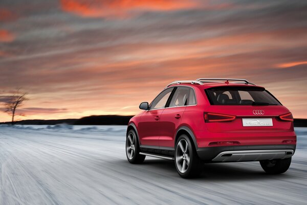 Voiture rouge de marque Audi sur une route enneigée