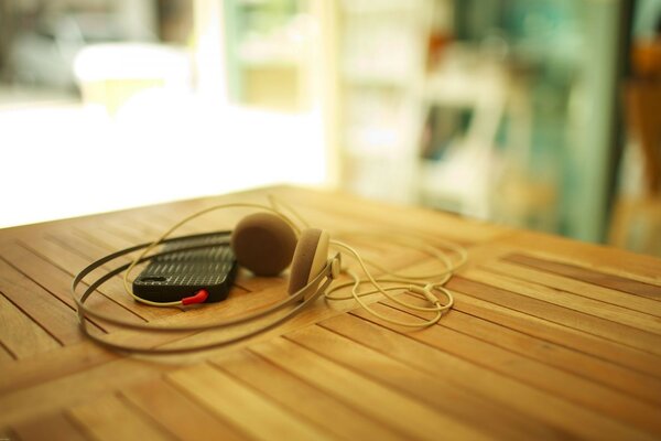 Fones de ouvido estão em uma mesa de madeira