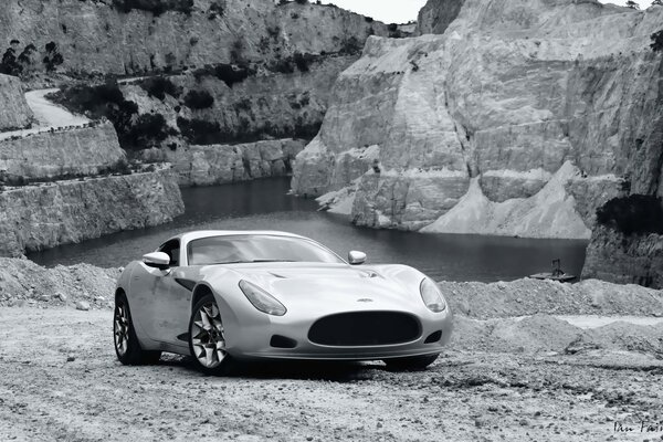 Coche gris en las montañas grises junto al lago gris