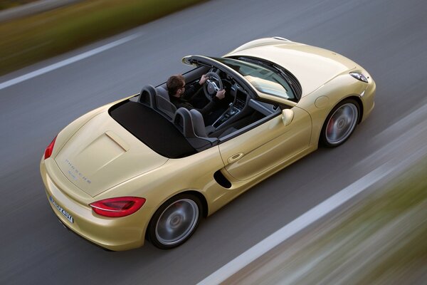 A man in a beige car drives away