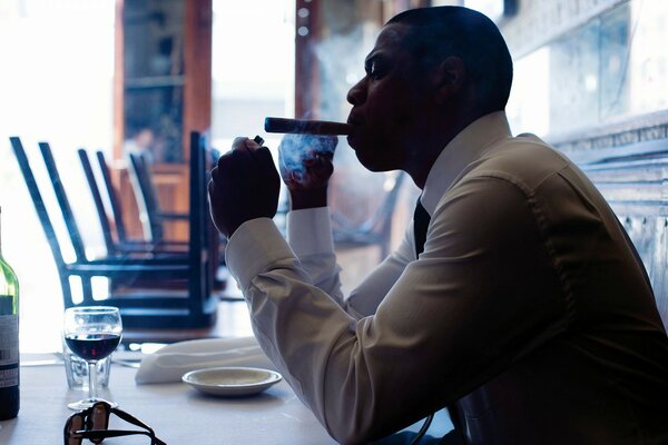 Hombre de negocios fumando con una Copa de vino