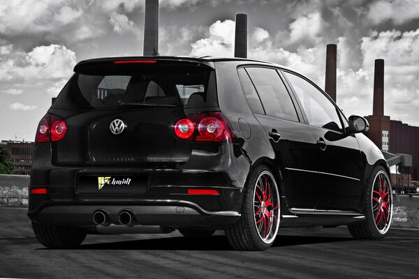 Black volkswagen with red wheels goes to the factory