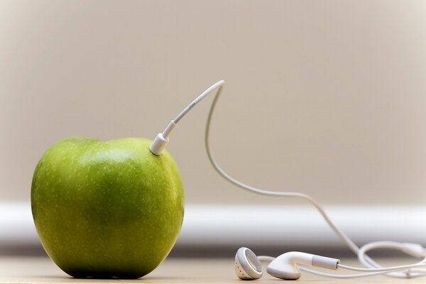 Still life green apple and headphones connected to it