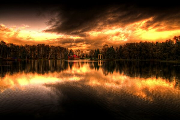 Helle Reflexion des Sonnenuntergangs und des Waldes auf dem Wasser