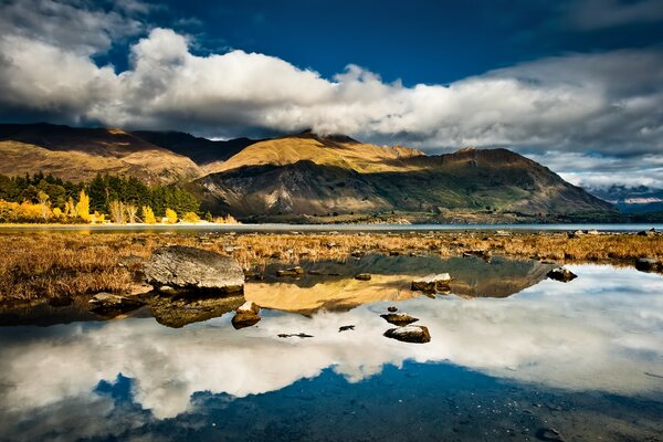 Beautiful mountains and sky with clouds are reflected in the lake