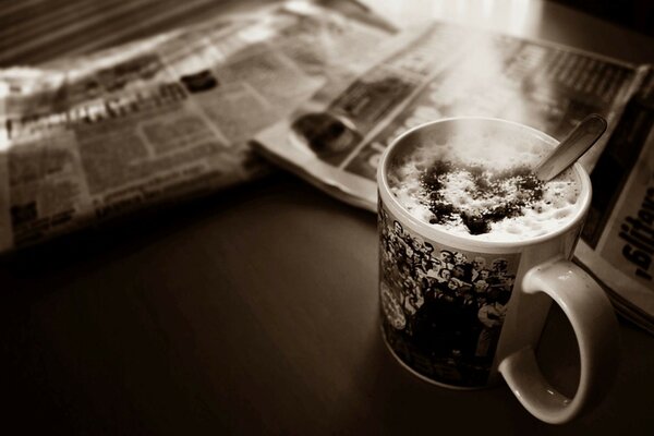 Taza de café espuma corazón periódico mesa foto sepia