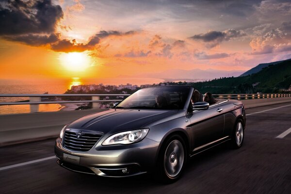 Hermoso coche en el fondo de la puesta de sol