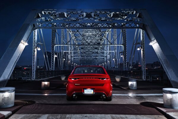 Rotes Auto auf der Nachtbrücke