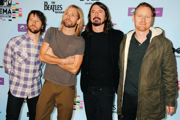 A musical group of four people posing for a photo