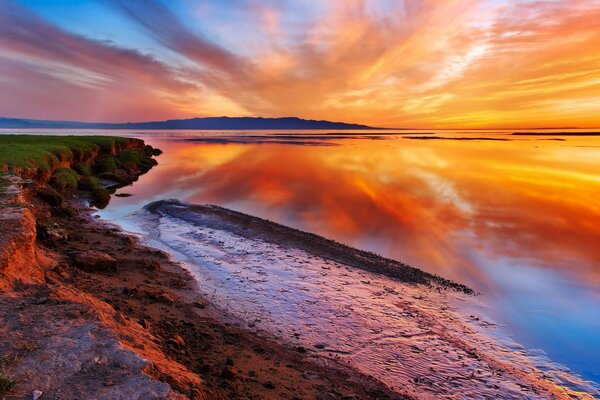 Красочный закат на песчаном берегу моря