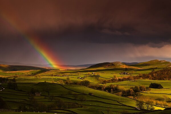 Rainbow at sunset in a hilly field