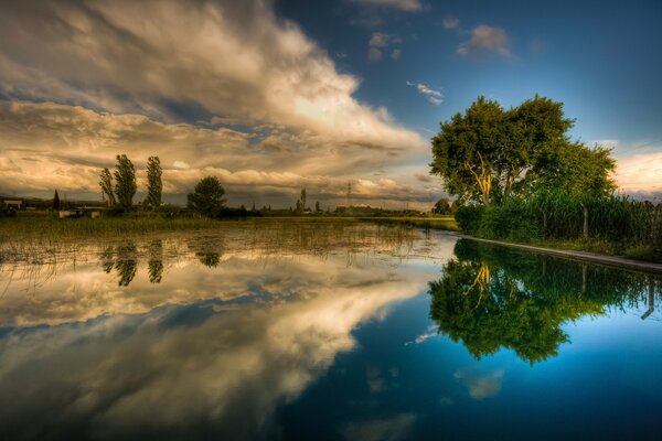 Paisaje del lago al atardecer con el reflejo de los árboles