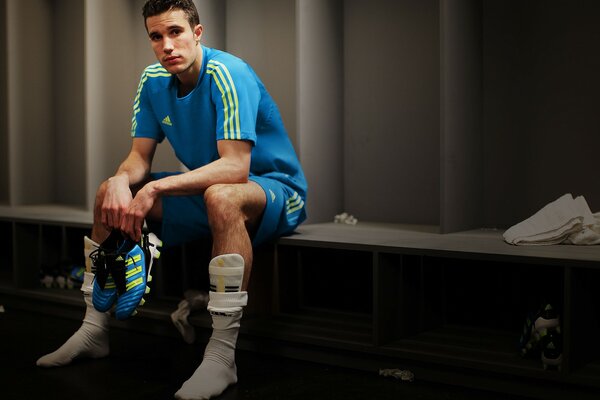 A tired football player in an empty locker room