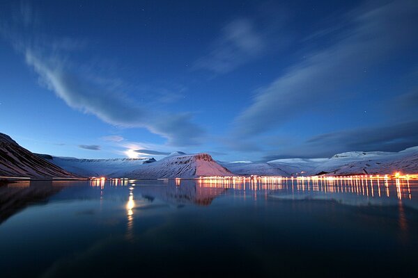 Colline innevate e lago al crepuscolo